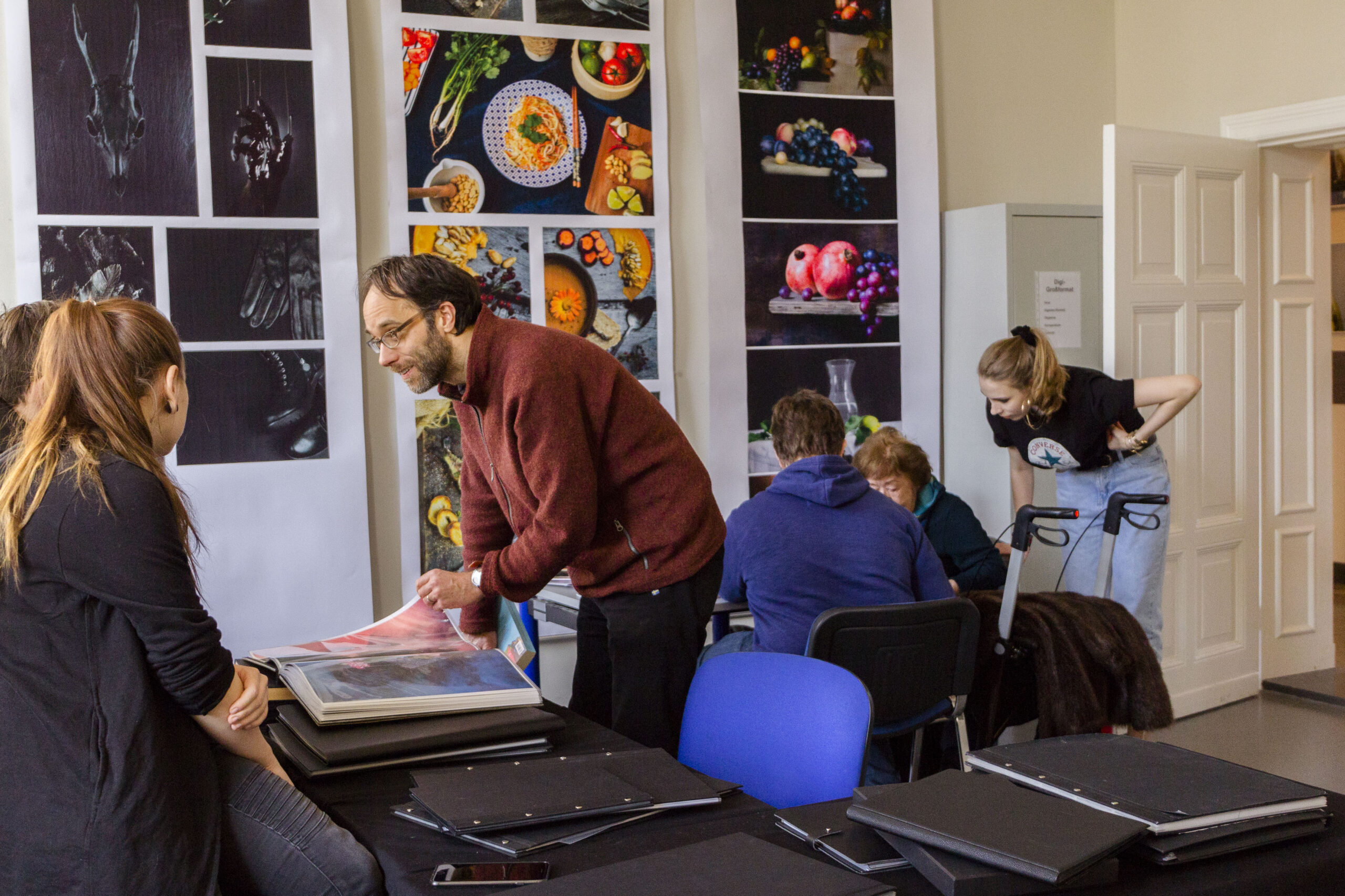 Dozent berät Designstudierende der Designschule Berlin bei der Portfolio-Durchsicht im Unterricht, professionelle Ausbildung im Grafik-Design als Investition in die Zukunft.